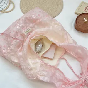Primer plano de bolso tote de organza rosa con lunares, lentejuelas y gran capacidad.