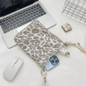 Telefoontasje met luipaardprint en verstelbare geknoopte band in kantooromgeving