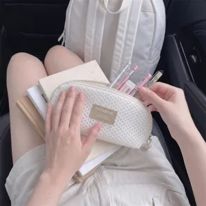 Minimalist mesh shell-shaped makeup brush storage bag used as a portable pencil case