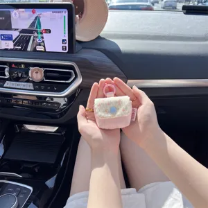 Primer plano de una funda acolchada rosa con flores para auriculares en un coche