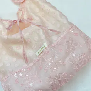 Vista detallada del bolso tote de organza rosa con lentejuelas y lazo elegante