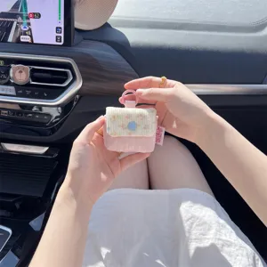 Primer plano de una funda acolchada para auriculares con flores sostenida en un coche.