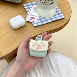 Primer plano de una funda acolchada con flores para auriculares y un botón de presión rosa.