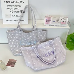 Close-up detail of stylish Korean canvas tote bags with embroidered star and dot patterns.