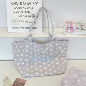 Detailed view of gray star-patterned canvas tote bag featuring Lucky letter embroidery.