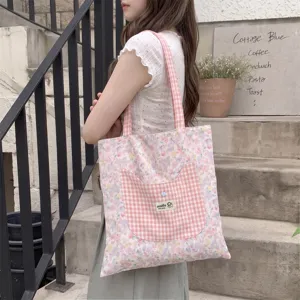 Floral tote bag with pink gingham cat pocket shown in a lifestyle outdoor setting