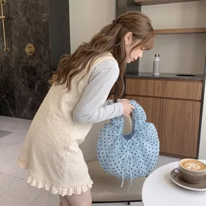 Primer plano de un bolso de organza con lunares azules en un entorno de estilo de vida.