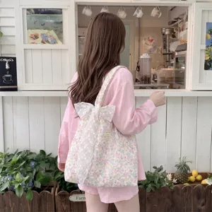 Floral canvas tote bag with large white lace bow detail shown from the back view