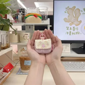 Primer plano de una bonita funda acolchada rosa con flores para auriculares en un escritorio