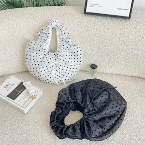 Vista detallada de bolsos de organza con lunares, diseño plisado elegante y lazos