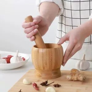 Detailed view of wooden mortar and pestle set for grinding garlic, spices, herbs and kitchen use.