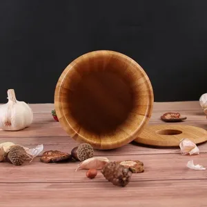 Detail view of a wooden mortar and pestle on a rustic wooden table with natural kitchen decor.