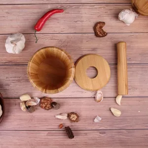 Wooden mortar and pestle set detail view, natural wood grain kitchen tool for grinding garlic.
