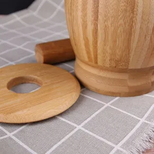Close-up detail view of natural wooden kitchen mortar and pestle set with lid on table.
