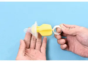 Detailed view of the yellow sponge baby nipple cleaning brush with a white handle.