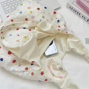 Detailansicht einer bunten Polka-Dot-Fransen-Einkaufstasche mit Reißverschlusstasche.