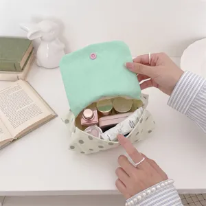 Vue détaillée d'une mini pochette à pois montrant sa grande capacité intérieure