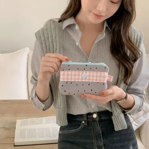 Close-up detail of a lifestyle scene showing a cute gingham star pattern pencil case pouch