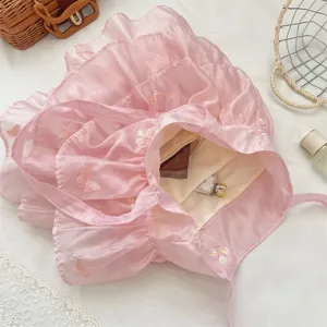 Vista detallada del bolso de organza rosa con volantes y delicado bordado de mariposas