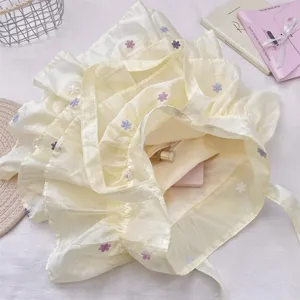 Detalle del bolso tote de organza amarilla con bordado floral y bolsillo interior.