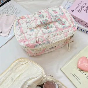 Detalle de bolsa de maquillaje floral acolchada con cremallera de cinta y relleno