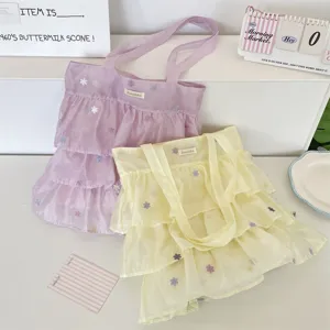 Vista detallada de los bolsos tote de organza con volantes y pequeñas flores bordadas