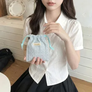 Close-up detail of a delicate blue lace drawstring pouch held by a model for storage