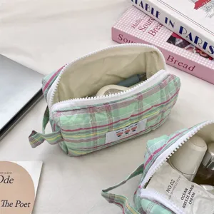 Macro view of interior storage space in a green plaid quilted cosmetic pouch.