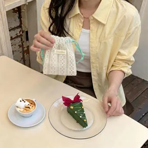 Detailed lifestyle view of a cream hollow-out lace drawstring bag for small items
