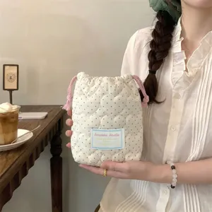 Bolsa de cordón acolchada con corazones blanco crema y lunares azules, con la modelo