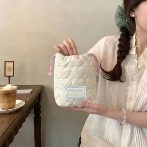 Primer plano de una bolsa acolchada con cordón en color crema y lunares