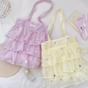 Vista detallada de bolsos de organza con volantes y bordado floral fino