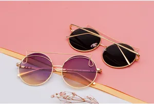 Detailed shot of two pairs of round cat-eye sunglasses with thin golden metal frames