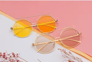 Close-up of cat-ear round sunglasses with gold metal frames and gradient lenses