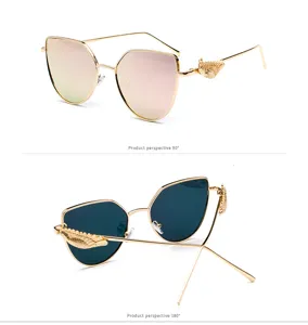 Detailed view of retro sunglasses featuring decorative embossed wing design on golden temples