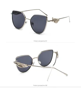 Close-up of retro sunglasses with unique embossed wing decorations on the silver temples.