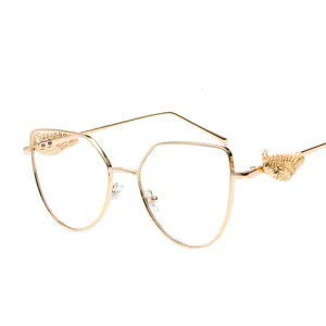Retro stylish gold metal frame glasses with embossed wing detail on white background