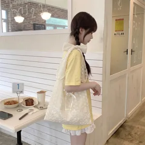 Gran bolso de organza blanca con lazo al hombro mostrado en el entorno de un café