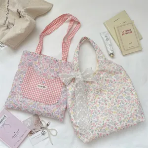 Detail view of floral tote bags with cat pocket and lace bow on fabric background
