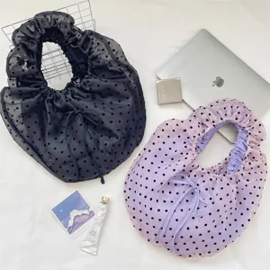 Detalle de bolsos de organza con lunares negros y lavanda y asas suaves plisadas