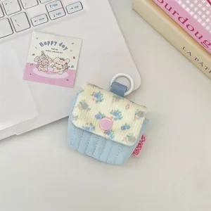 Detalle de funda de auriculares acolchada floral con botón a presión y solapa azul