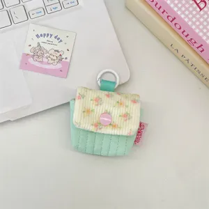 Detalle de funda acolchada para auriculares con estampado floral y botón rosa