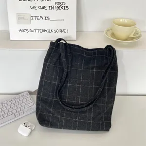 Vintage dark grey checkered canvas tote bag shown in a professional desk lifestyle setting