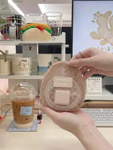 Minimalistische beige Mesh-Tasche in Muschelform zur Aufbewahrung von Elektronik.