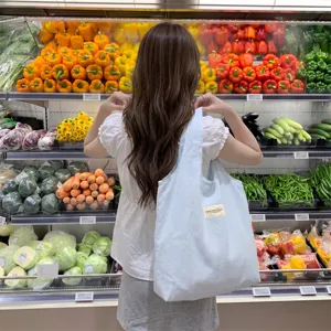 Große makaronblaue Canvas-Einkaufstasche für Studenten in einem Supermarkt-Ambiente