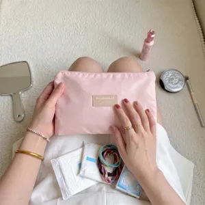 Detailopname van een roze draagbare opbergtas met rits vastgehouden voor make-up spullen