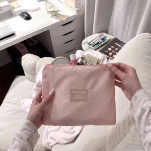 Detailopname van een roze nylon opbergetui met make-up artikelen