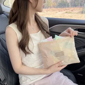 Gedetailleerd zicht op een draagbare beige opbergtas met rits voor make-up in een auto