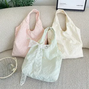 Detailed view of cherry blossom embroidery tote bags in three pastel colors