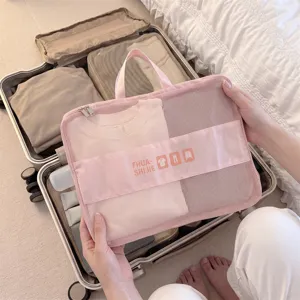 Detail view of a pink mesh travel packing cube used for clothing storage in a suitcase